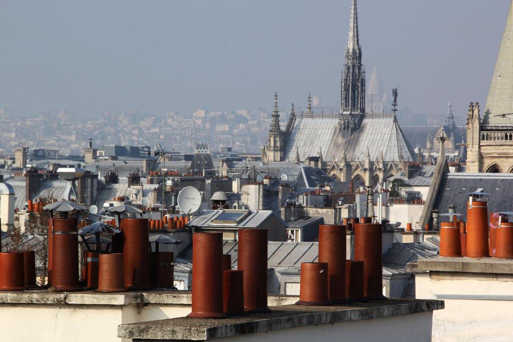 une vue sur une ville avec des tuyaux rouges sur un bâtiment dans l'établissement Pick A Flat's Apartments in Saint Michel - Rue Du Sommerard, à Paris