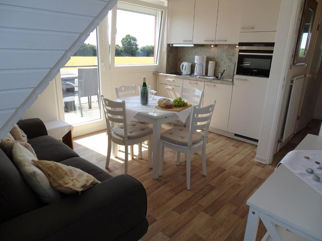 a kitchen and dining room with a table and chairs at Haus Wildfang FeWo 2 in Dahme