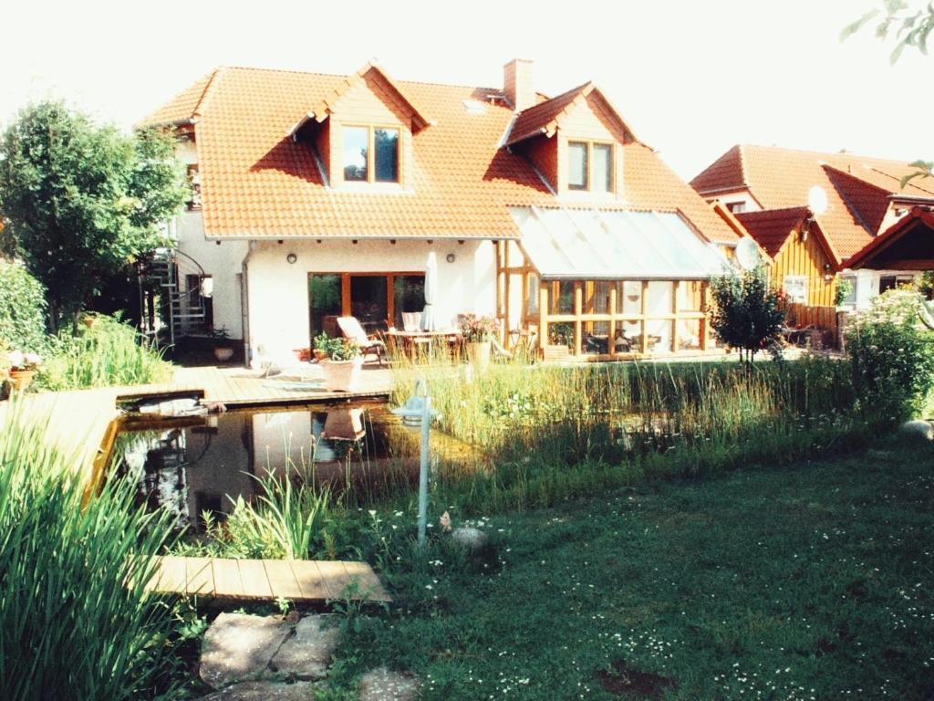 a house with a pond in the yard at Ferienwohnung Marberth in Hildesheim