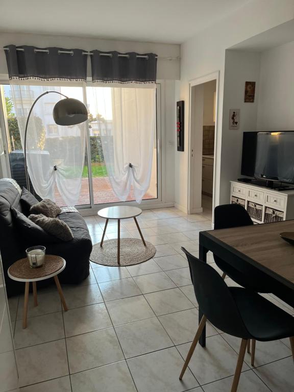un salon avec un canapé et une table dans l'établissement Logement plein centre royan, à Royan