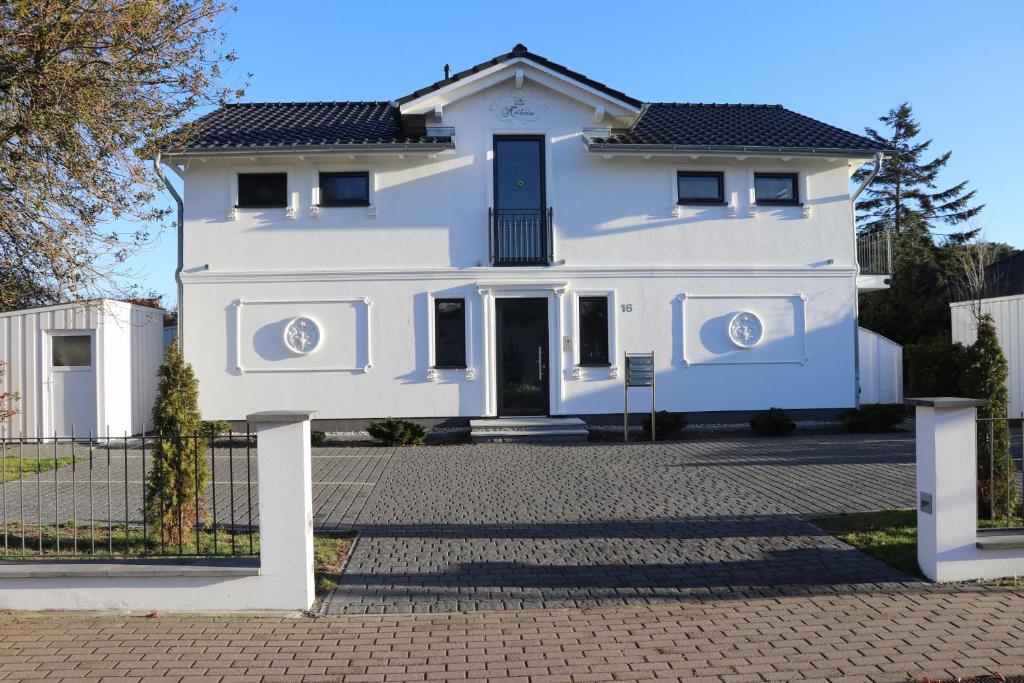 a white house with a fence in front of it at "Auszeit" in der Villa Katharina in Dierhagen