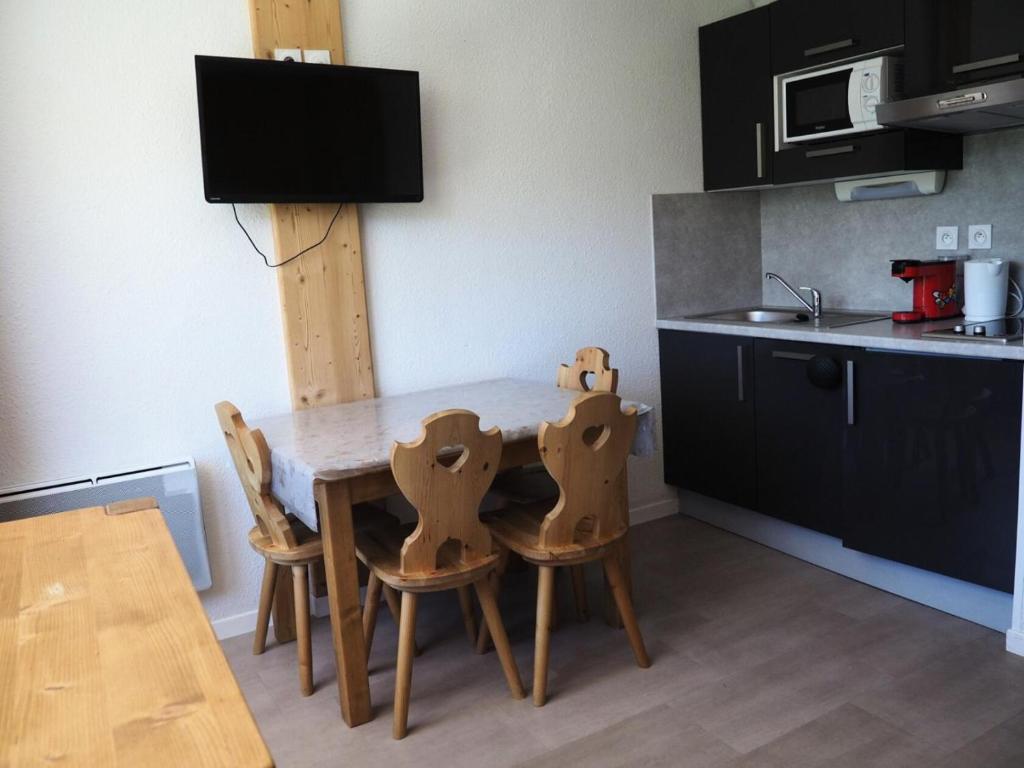 une cuisine avec une table et des chaises dans une cuisine dans l'établissement Résidence Median - Studio rénové · Proche des pistes · Balcon MAE-1764, aux Menuires