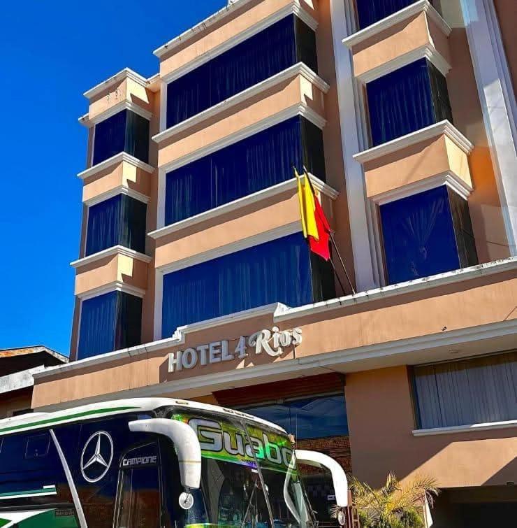 a bus parked in front of a hotel with a flag at Hotel 4 Rios in Cuenca