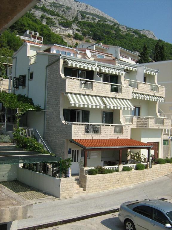 a large building with a car parked in front of it at Apartmani Šperanda Pisak in Pisak