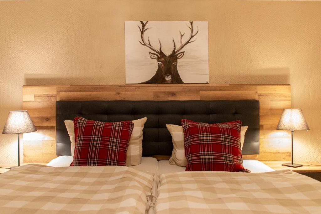 a bedroom with a bed with two red pillows at Hof Timmermann - Spatzennest in Ottenstein