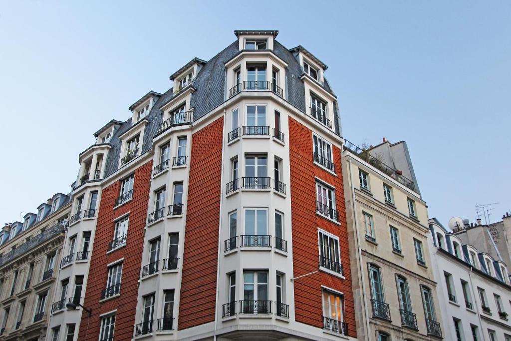 wysoki ceglany budynek z balkonami na górze w obiekcie Pick A Flat's Apartments in Saint Michel - Rue Du Sommerard w Paryżu