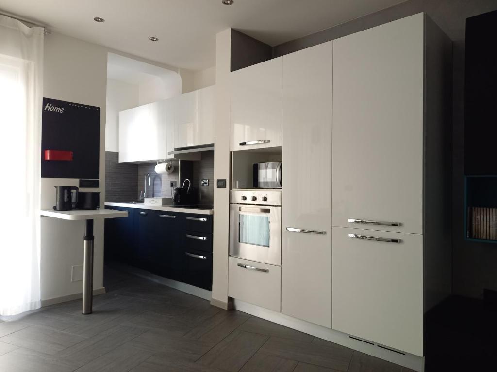 a kitchen with white cabinets and a stove top oven at La Casa di Saretta in Trieste