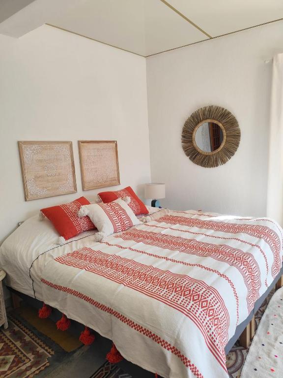 a bedroom with a bed with red pillows and a mirror at Casa Louisa in Serralongue