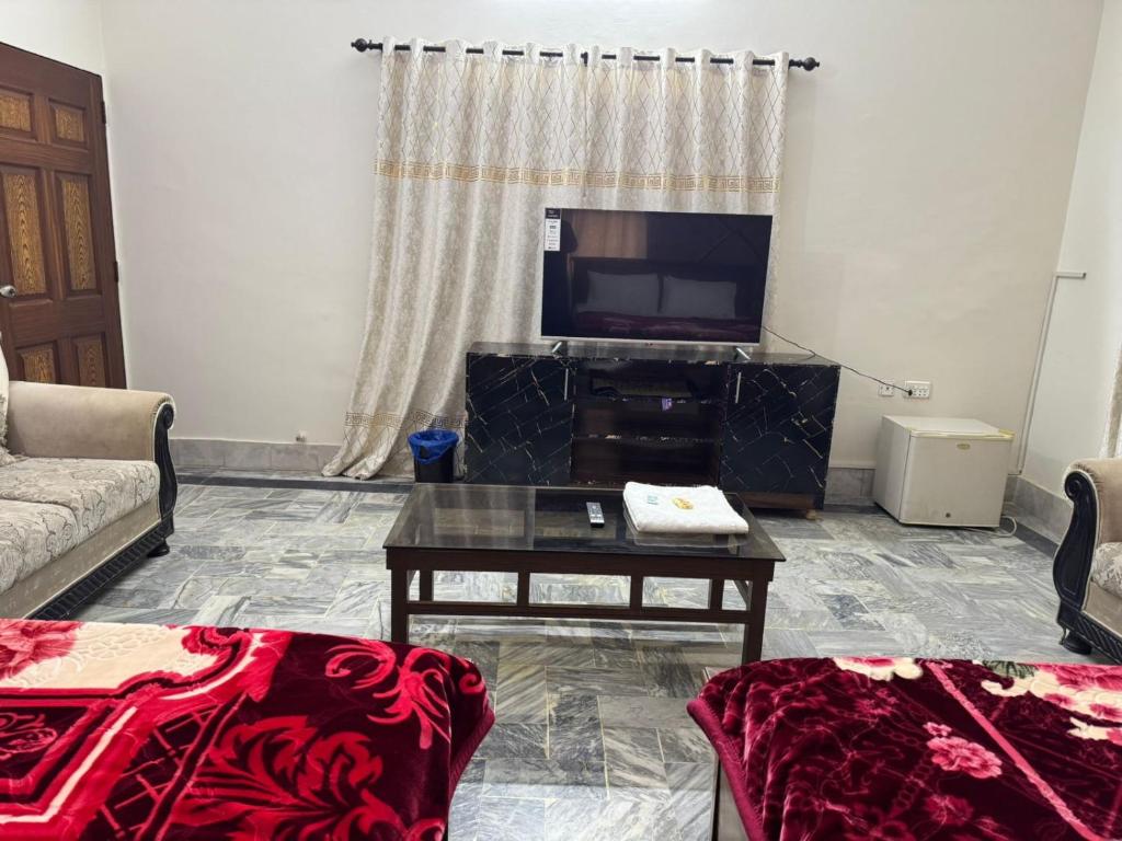 a living room with a tv and a coffee table at AWARI in Guest House in Hyderabad