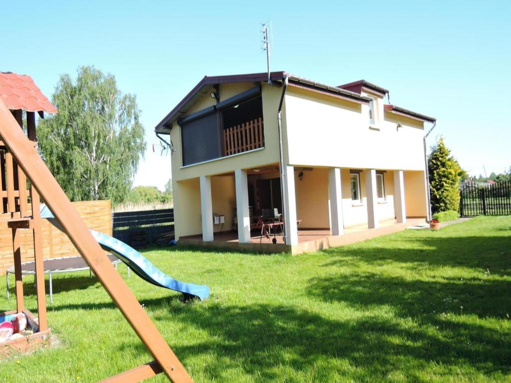 a house with a slide in the yard at Holiday Home near Baltic Sea & Sandy Beaches in Międzyzdroje