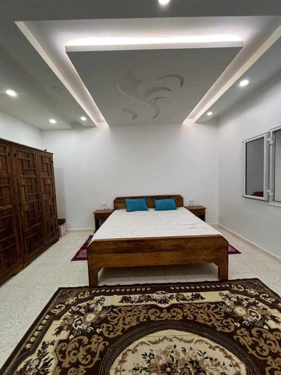 托泽尔Maison Chebbi的卧室里有一张床，上面放着蓝色的枕头