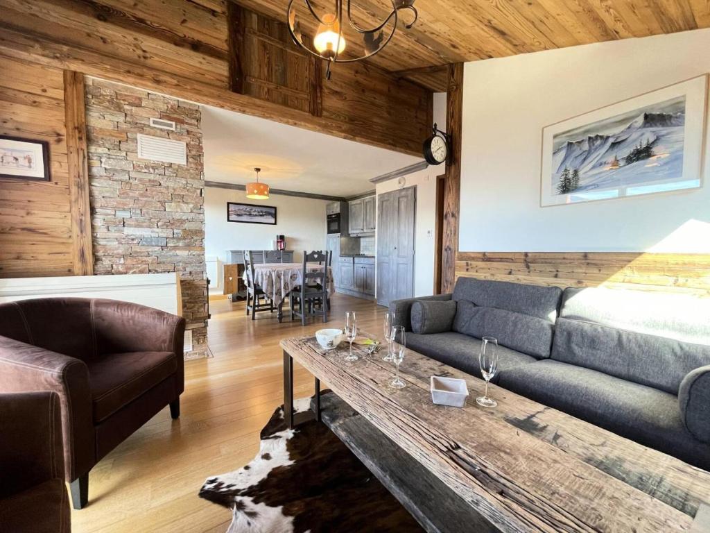 un salon avec un canapé et une table dans l'établissement Résidence Les Logis De Bellecombe - Appartement de charme proche des pistes et du centre MAE-5251, à Notre-Dame-de-Bellecombe