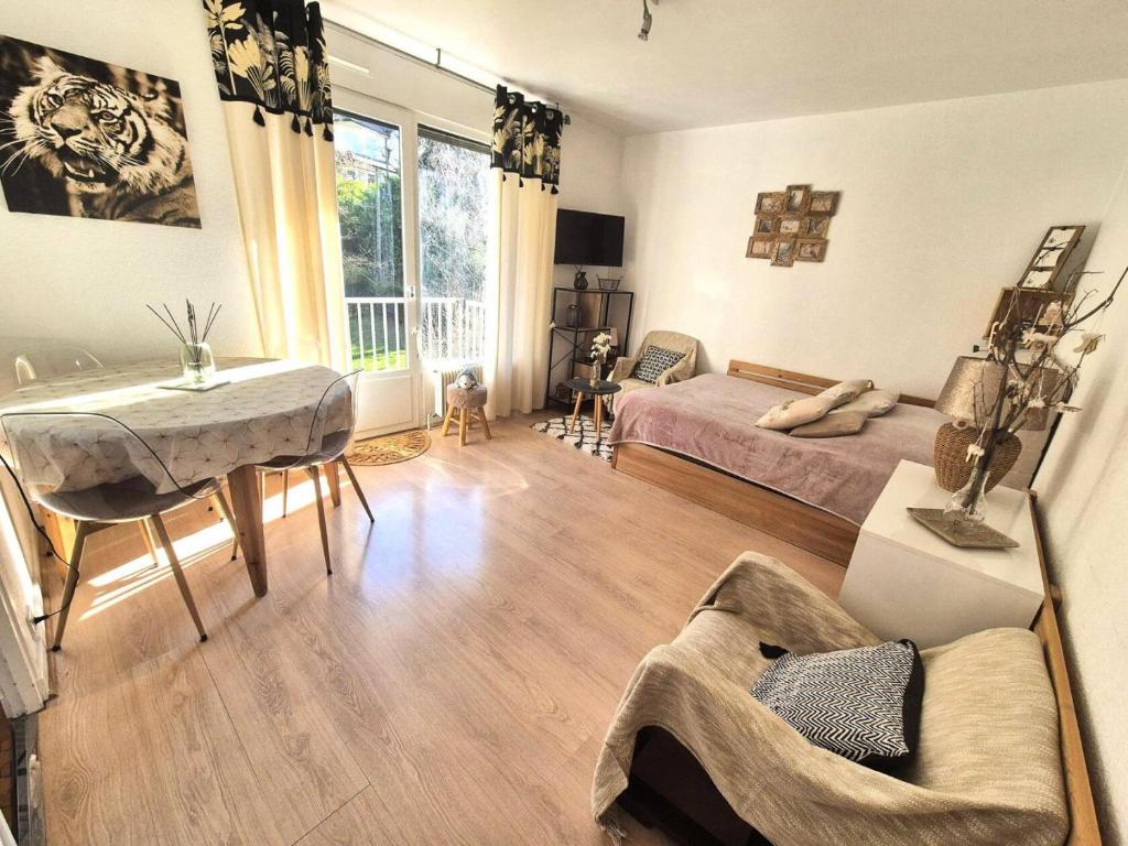 un salon avec deux lits et une table dans l'établissement Résidence Montcalm D - Chaleureux logement ! MAE-6704, à Aix-les-Bains