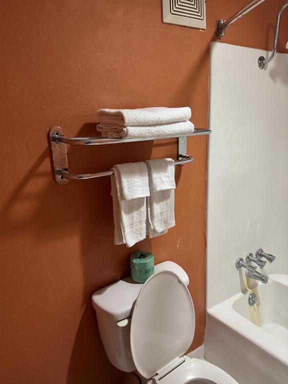 ein Badezimmer mit Toilette und Waschbecken sowie Handtüchern in der Unterkunft labh inc Motel in Norfolk