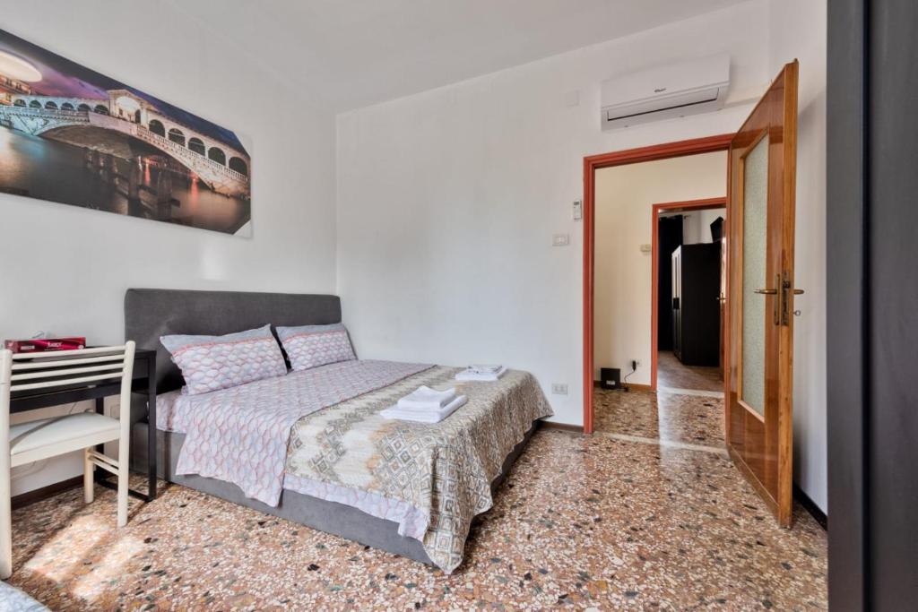 a bedroom with a bed and a desk and a train painting at Cozy Best Apartment In City With Free Parking in Venice