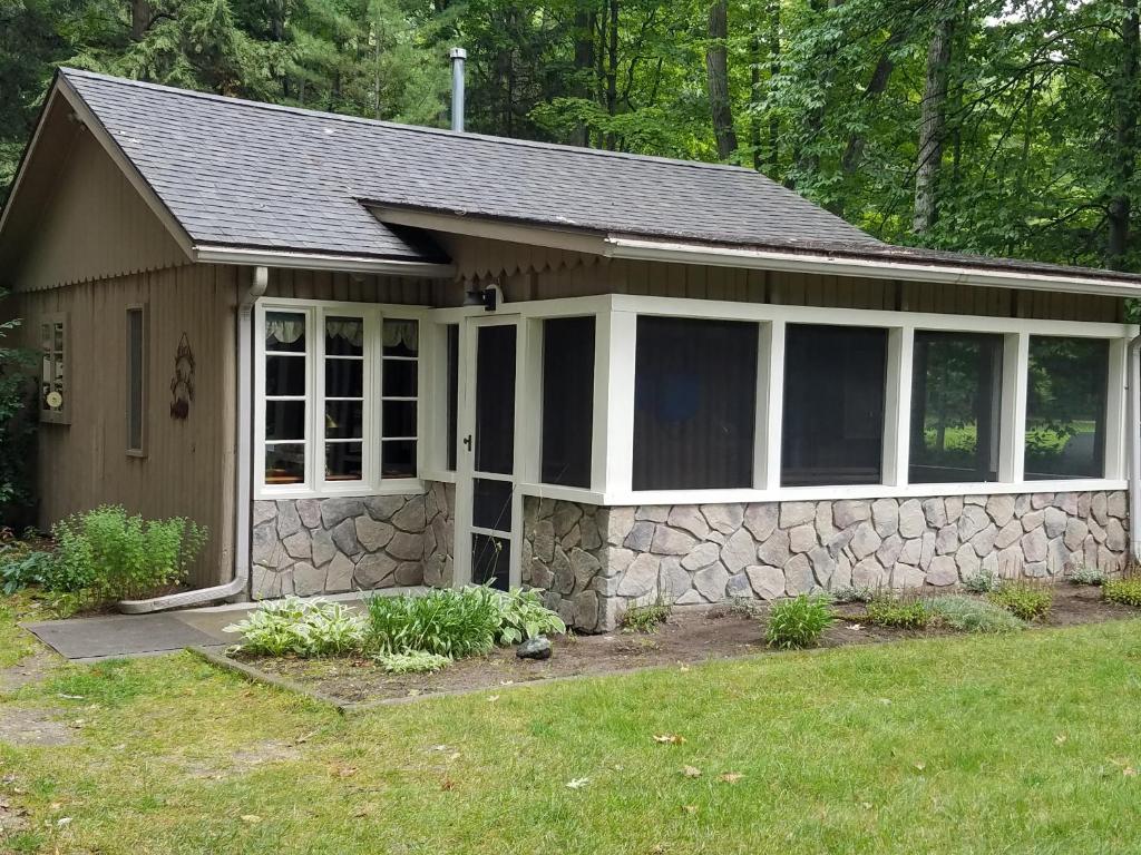 a small house with a stone wall at Lake Access! Twin Birch Resort - The Brown Bear in Honor