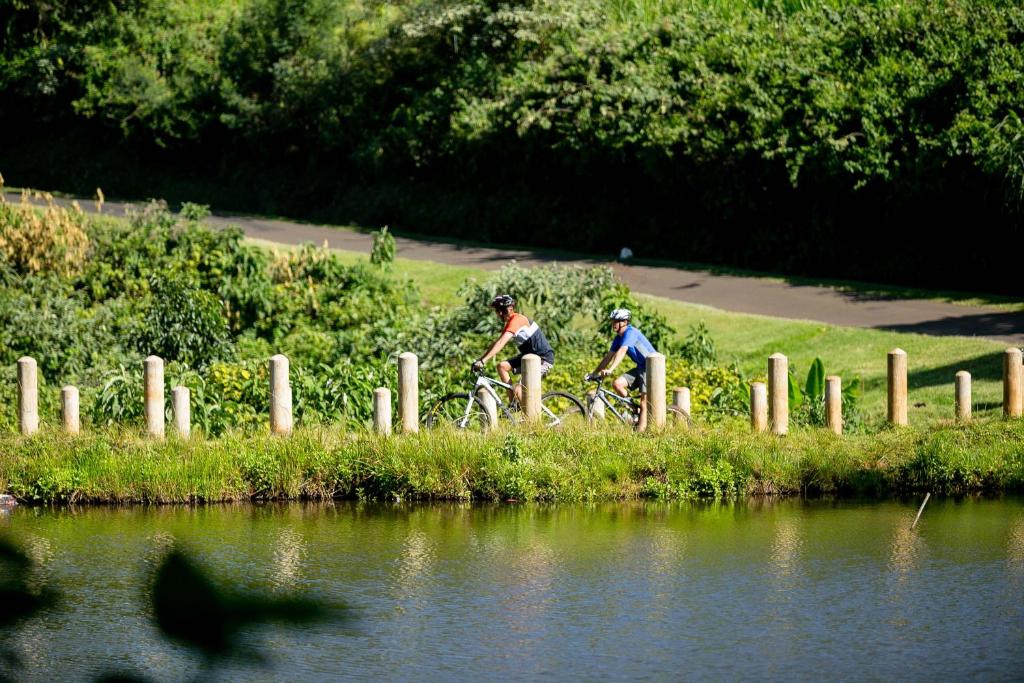 2 personnes voyageant à vélo par une masse d'eau dans l'établissement Brackenhurst Hotel and Conferences, à Limuru