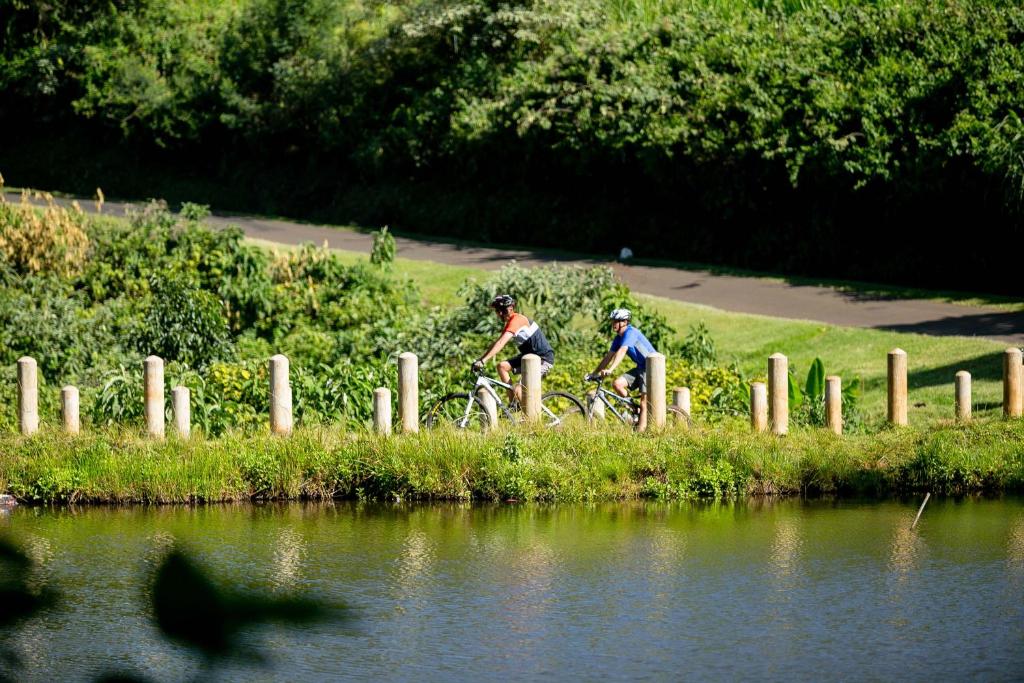 two people riding bikes by a body of water at Brackenhurst Hotel and Conferences in Limuru