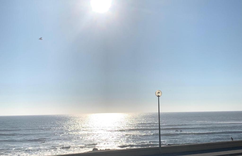 a view of the ocean with a street light at Aver Beach Haven in Póvoa de Varzim