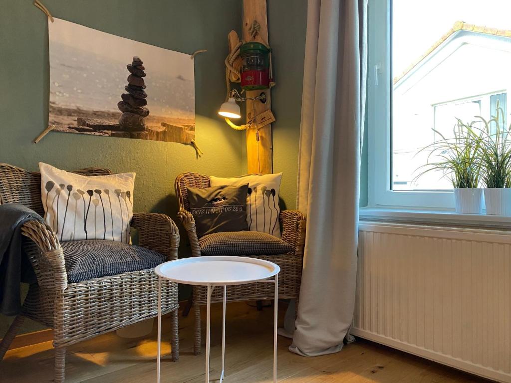 a room with two chairs and a table and a window at Haus AchternDiek Strandhafer in Dahme