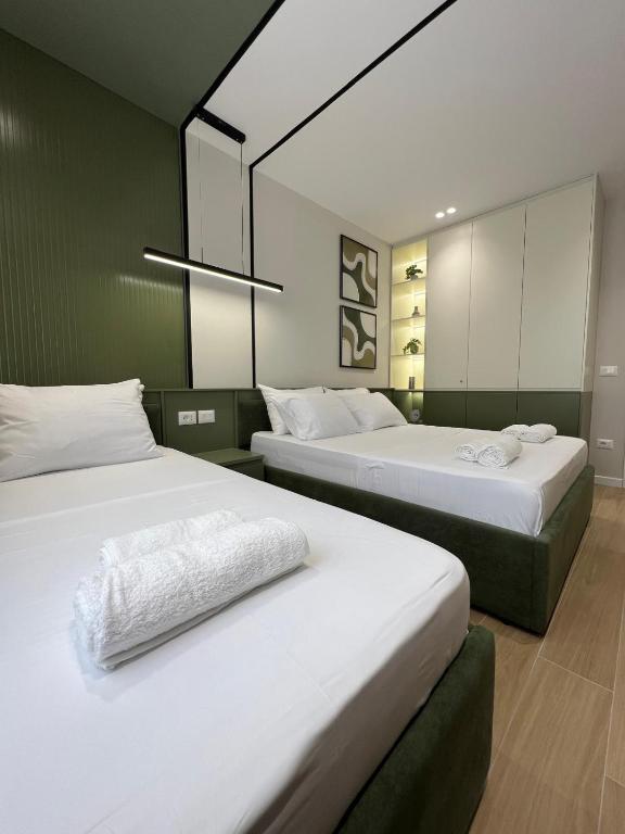 a bedroom with two beds and a mirror at Noir luxury apartment in Durrës