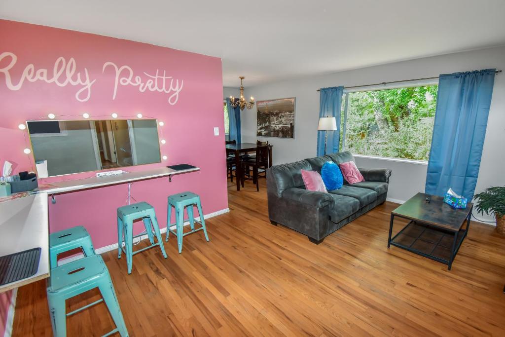 a living room with a pink wall with a desk and stools at Super Cute Five Bedroom Home in Denver Perfect For Girls Trips in Denver