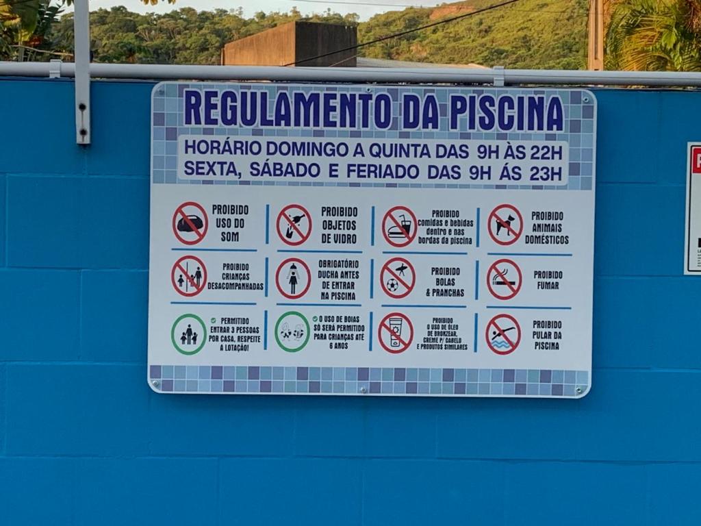 a sign on the side of a building with prohibited signs at Casa 23 em Condomínio à 700m da Praia dos Astúrias Guarujá - SP in Guarujá