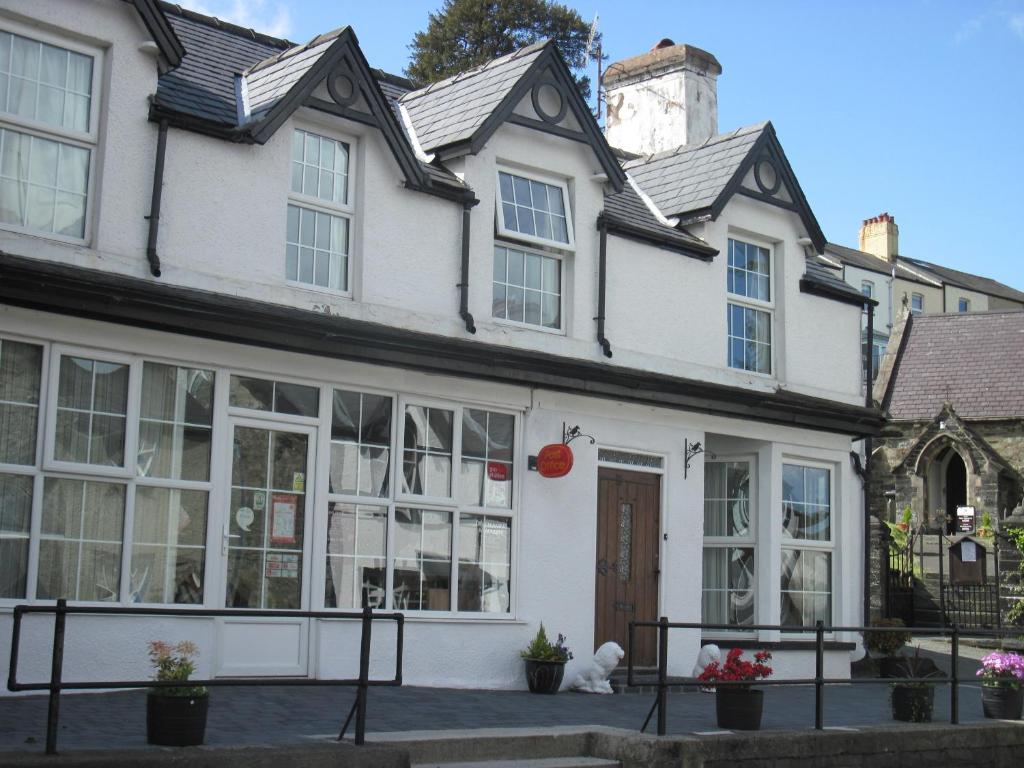 a white house with large windows at B&B Ty Cornel in Trefriw