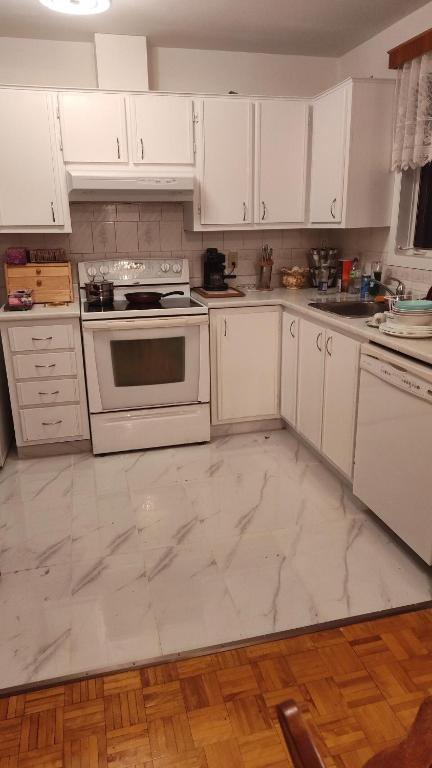 a white kitchen with white cabinets and an oven at Family-Friendly in Quiet Laval Neighborhood in Laval