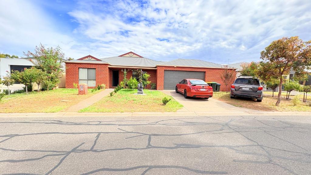 a house with two cars parked in front of it at Cozy comfortable House in Mildura