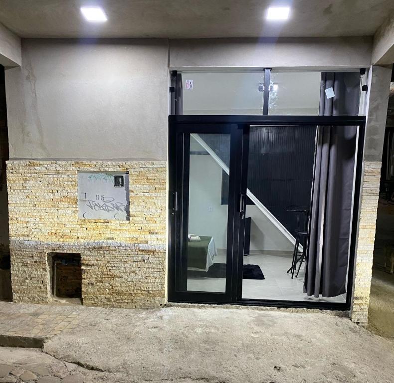 a glass door of a building with a staircase at Suite centro in São Thomé das Letras