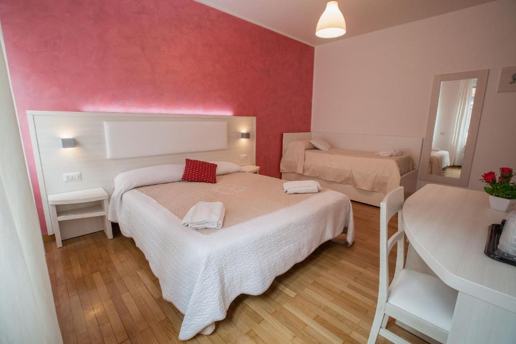 ローマにあるB&B Momenti Romaniの小さな部屋で、ベッド2台、鏡が備わります。