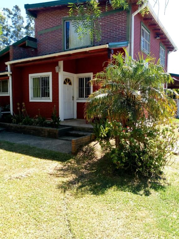 a red house with a tree in front of it at Cabaña Pope 2 in Federación
