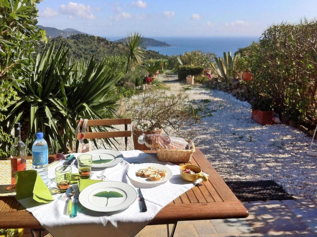 une table en bois avec une assiette de nourriture dessus dans l'établissement Holiday Home in Le Lavandou with Sea View, au Lavandou