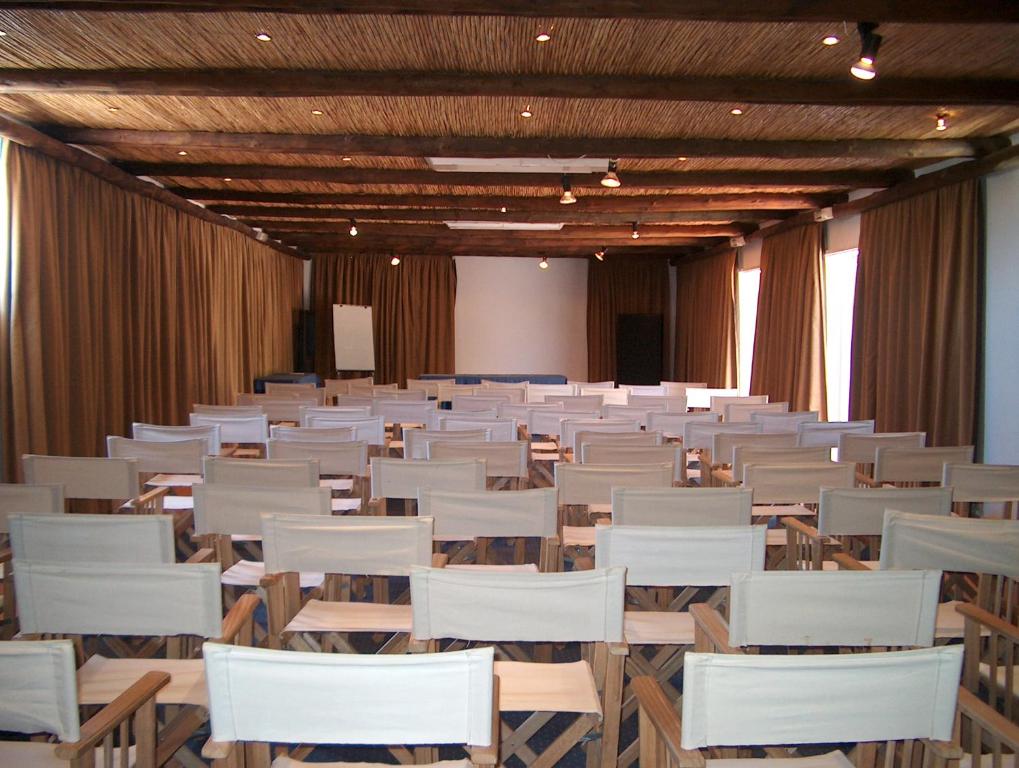 an empty room with white chairs and a stage at Pedras D'el Rei in Tavira