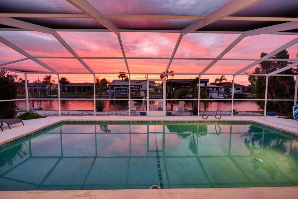 una piscina al atardecer con en Private Dock Heated Pool Hot Tub Game Room Fun, en Apollo Beach