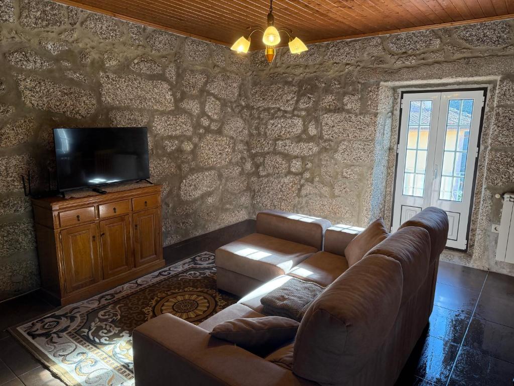 a living room with a couch and a television at Moradia do Pátio in Arcos de Valdevez