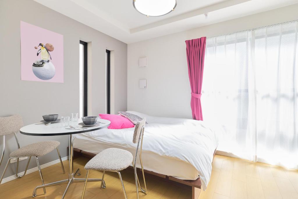 a bedroom with a bed and a table and chairs at Ruygo Setagaya by Tranova in Tokyo