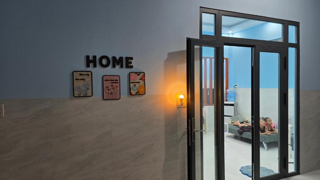 a room with a home sign and a glass door at Dan Family Homestay in Ấp Bình Hưng