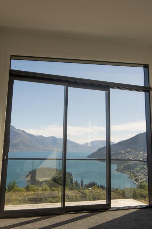 Zimmer mit einem großen Fenster mit Blick auf das Wasser in der Unterkunft 1Queenstown - Stunning Lake and Mountain Views in Queenstown