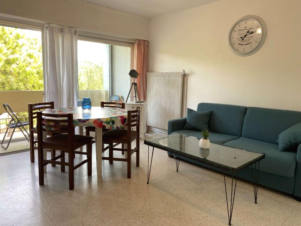 un salon avec un canapé bleu et une table dans l'établissement Appartement T2 confortable avec Wifi, loggia spacieuse, garage à Balaruc-les-Bains - FR-1-553-289, à Balaruc-les-Bains