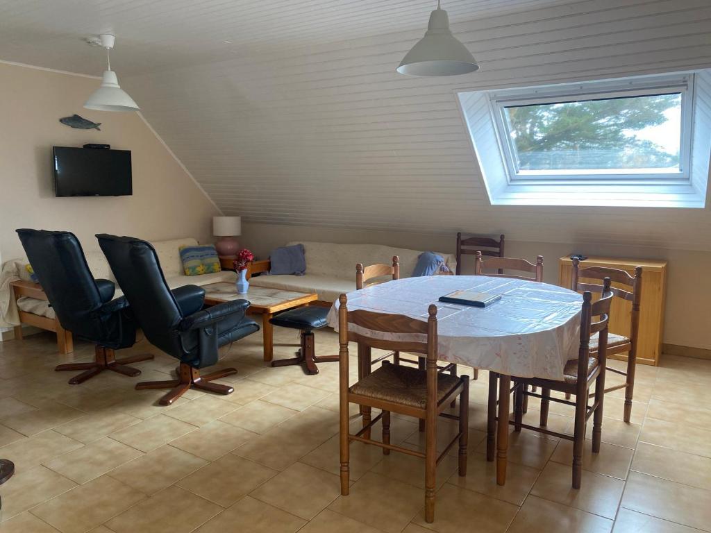 un salon avec une table et des chaises de salle à manger dans l'établissement Appartement 1er étage avec jardin et parking près de Le Palais - FR-1-418-263, au Palais