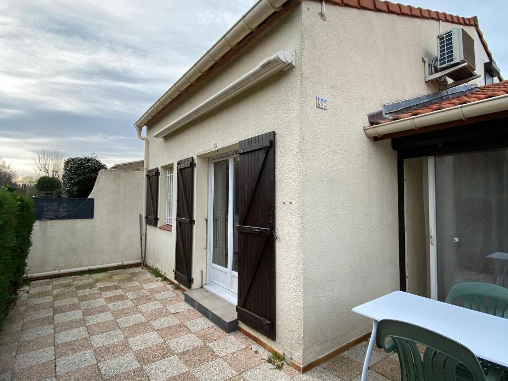 Cette petite maison dispose d'une table et d'une terrasse. dans l'établissement Charmant pavillon T3 à Argelès-sur-Mer, proche de la mer - FR-1-732-100, à Argelès-sur-Mer