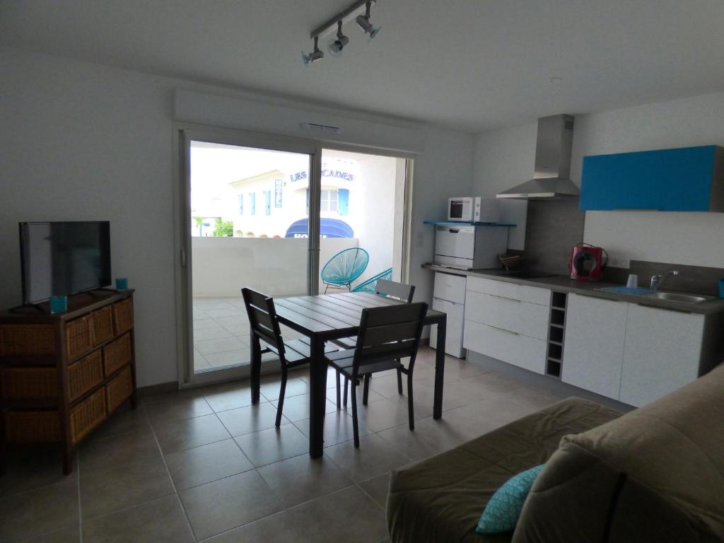 une cuisine et une salle à manger avec une table et des chaises dans l'établissement Appartement climatisé avec parking, proche mer, pour 4 pers. - FR-1-475-199, à Saintes-Maries-de-la-Mer