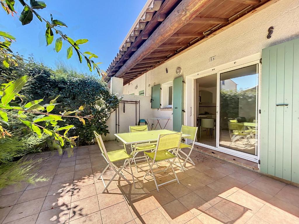 un patio avec une table et des chaises sur un patio dans l'établissement Appartement 4 pers avec piscine et parking à Saintes-Maries-de-la-Mer - FR-1-475-198, à Saintes-Maries-de-la-Mer