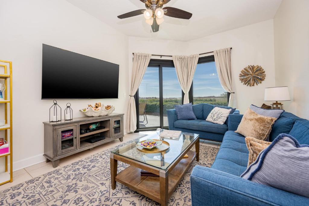 a living room with a blue couch and a tv at Phoenix VII 7015 condo in Orange Beach