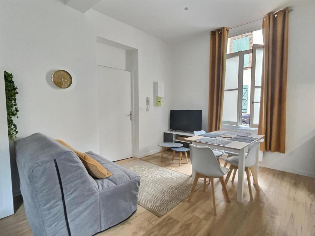 a living room with a couch and a table at Esprit Cosy - Coeur de Village in Nègrepelisse