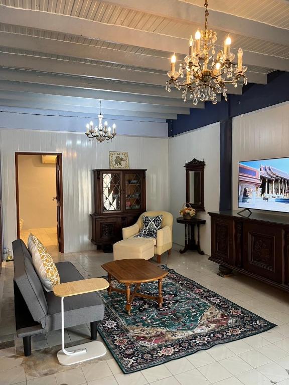a living room with a couch and a tv at Baan Saen Saran residence in Sathani Bang Ramat