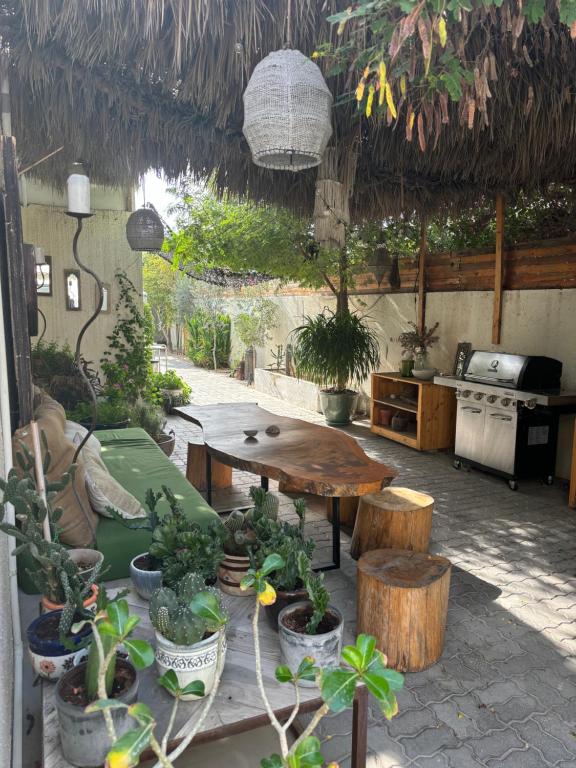 un patio con una mesa y un montón de macetas en Private Cottage with bbq area 5 min walk to beach!, en Dubái