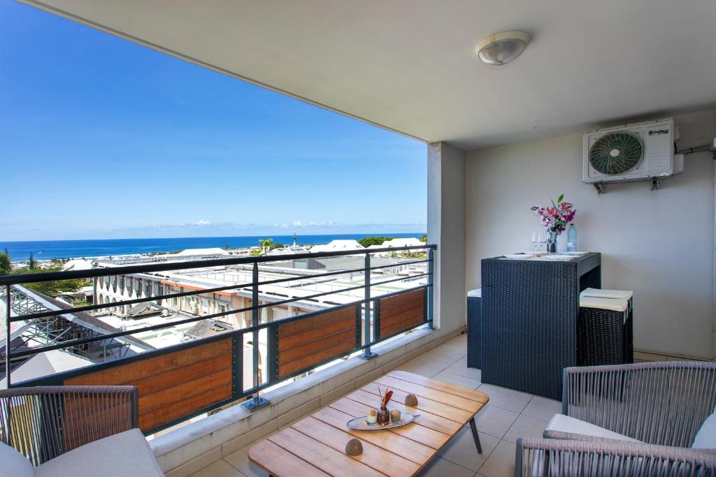 a balcony with a table and a view of the ocean at TI KAZ BONER Vue Mer in Saint-Pierre